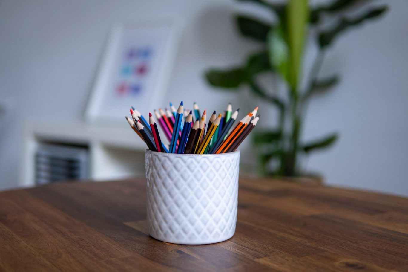 Becher mit bunten Stiften. Behandlungszimmer im Hintergrund.